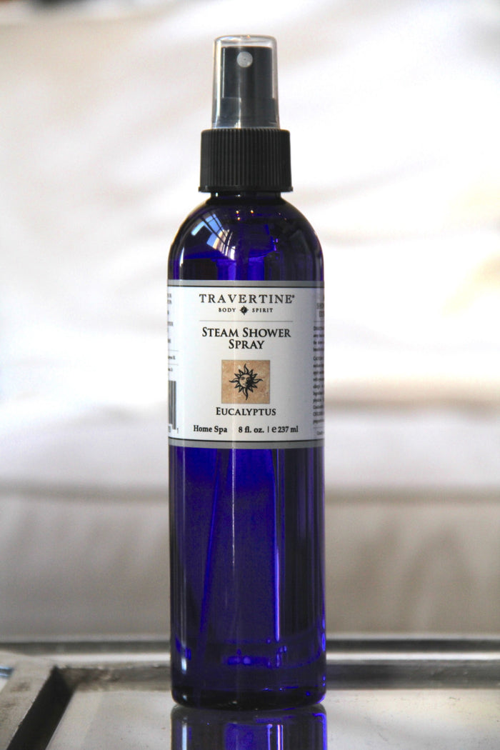 Close-up of a blue spray bottle labeled Eucalyptus Steam Shower Spray | Travertine Spa, designed for home spa wellness and aromatherapy use.