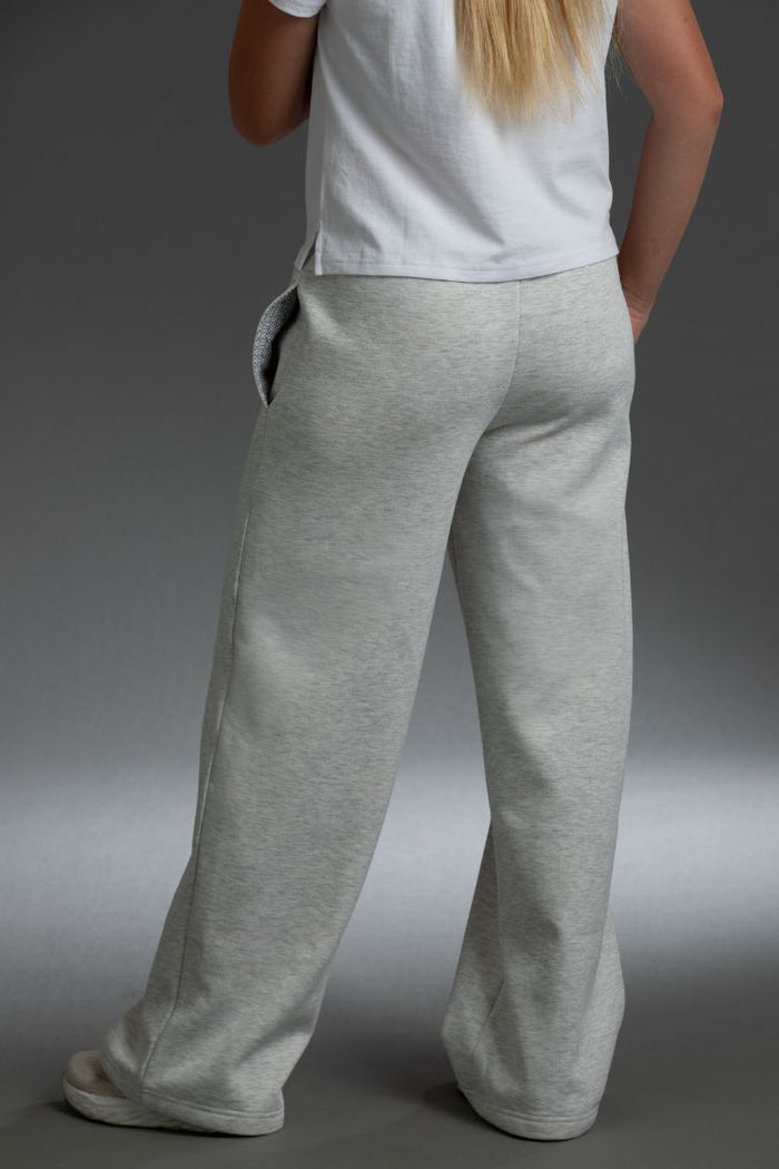 Person wearing gray sweatpants and a white shirt on a plain background || light heather gray
