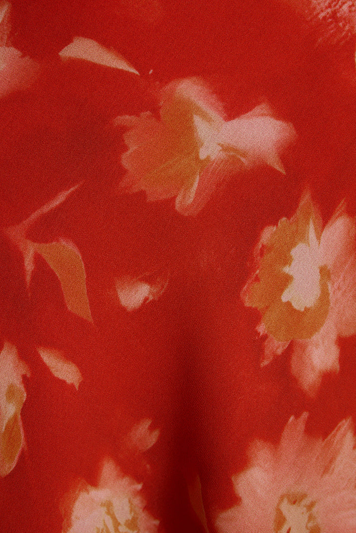 Close-up of poppy red floral print fabric on the Natalia strapless maxi dress.