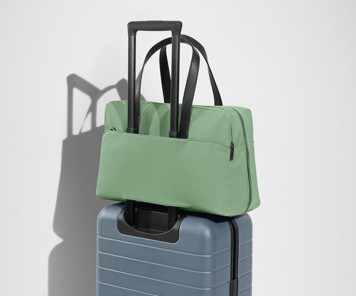 The Everywhere Bag secured to an Away suitcase by its trolley sleeve
// Our Everywhere Bags are designed with a trolley sleeve that slides onto your suitcase to keep it in place while you’re on the move. Paired with The Bigger Carry-On.