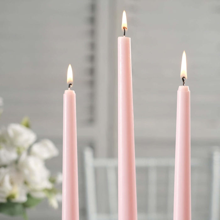 Three pink candles lit, standing tall against a soft background.