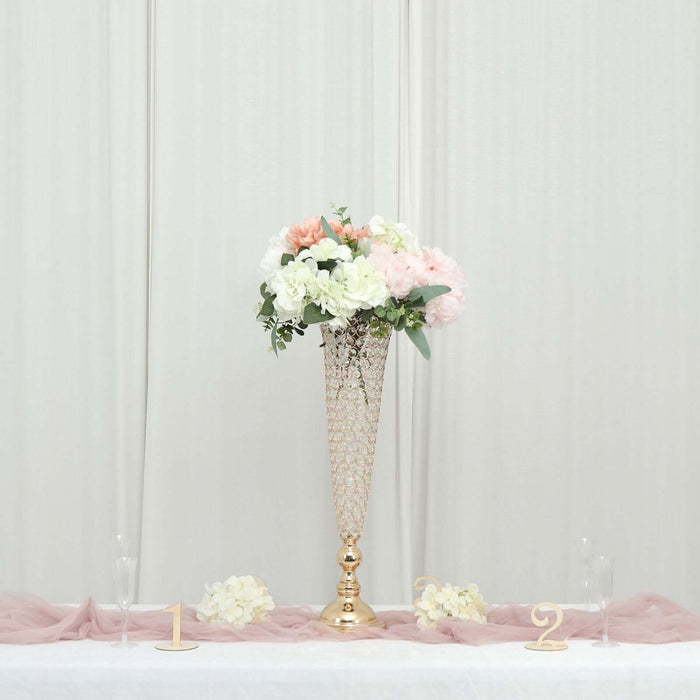 Elegant floral arrangement in a gold vase on a tabletop.