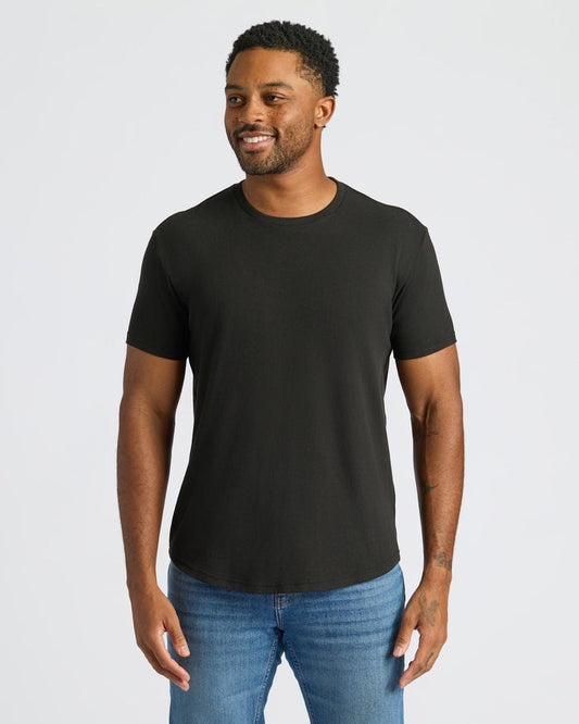 Man wearing a black t-shirt and blue jeans on a white background
