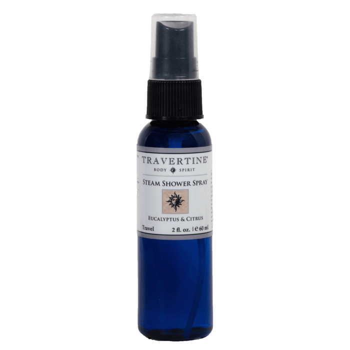 Blue spray bottle of Eucalyptus + Citrus Steam Shower Spray | Travertine Spa with black spray nozzle and white label featuring natural wellness branding for skincare and body care.