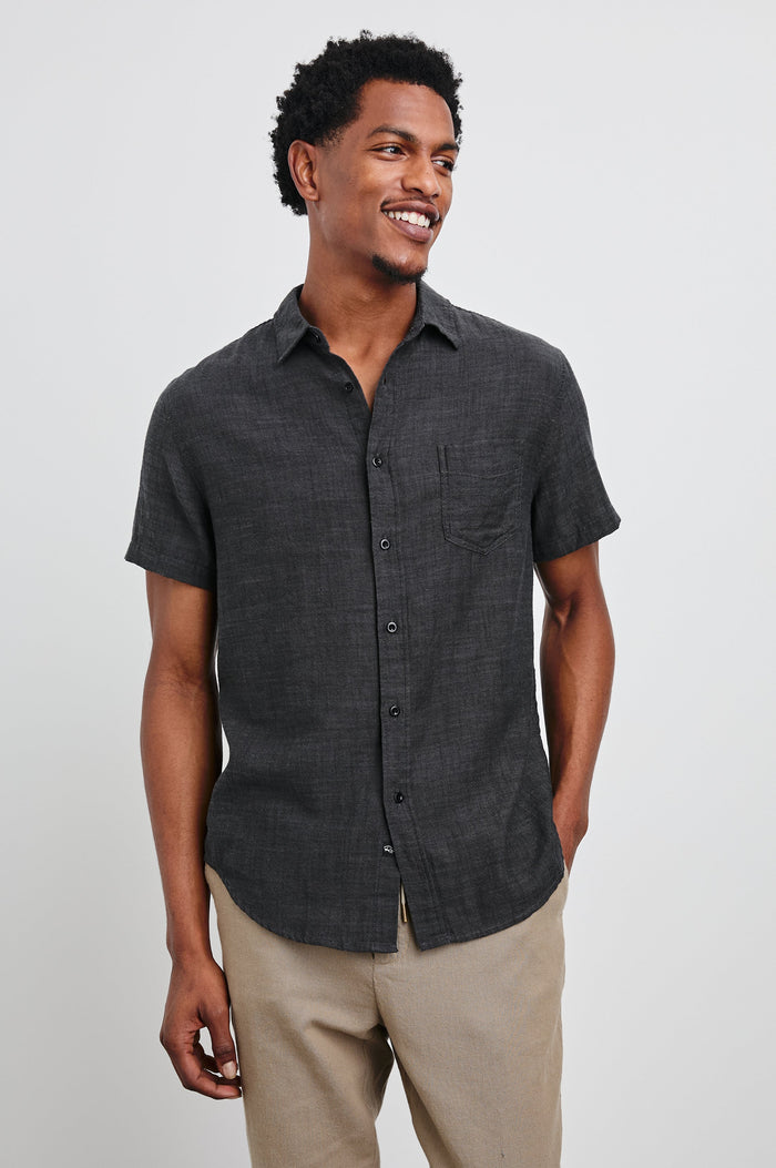 Fairfax Short-Sleeve Button Up with a Chest Patch Pocket in Black Chambray Colorway - Front View Featured on Model