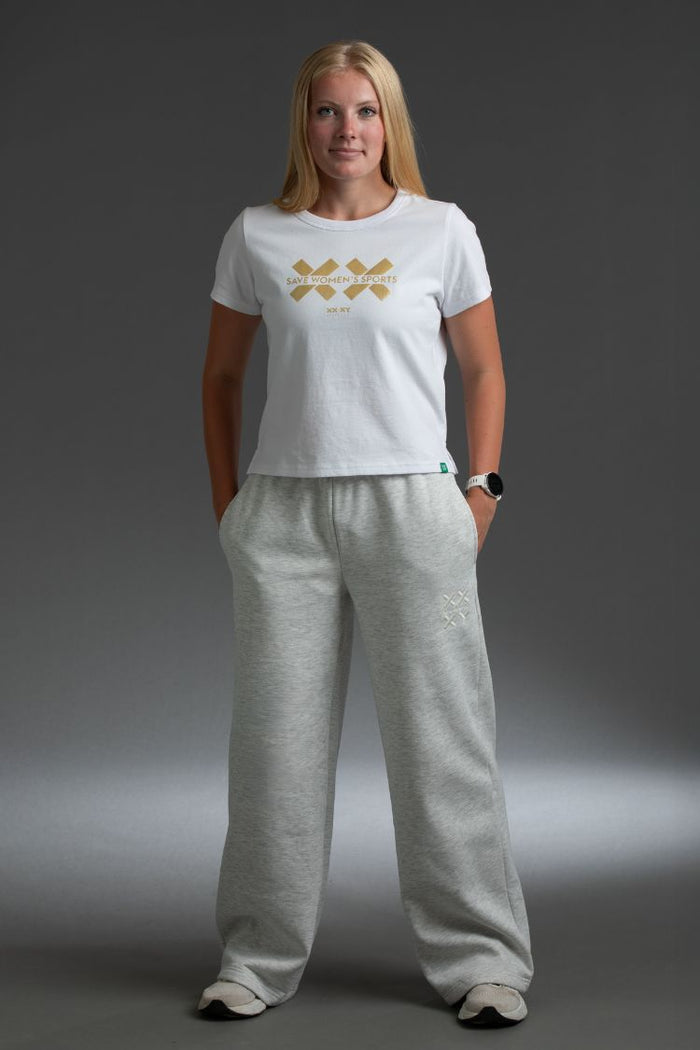 Woman wearing a white t-shirt with a logo and gray sweatpants || light heather gray