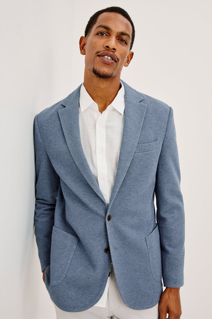 Lorenz Blazer in Nylon With Single Breasted Front Buttons, Single Chest Patch Pocket, Side Patch Pockets, and Long Sleeves in Heather Blue Colorway - Upper Body Front View Featured on Model