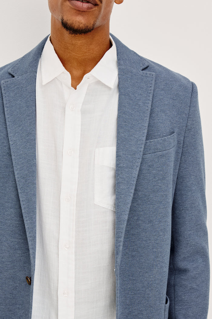 Lorenz Blazer in Nylon With Single Breasted Front Buttons, Single Chest Patch Pocket, Side Patch Pockets, and Long Sleeves in Heather Blue Colorway - Close up Front View Featured on Model