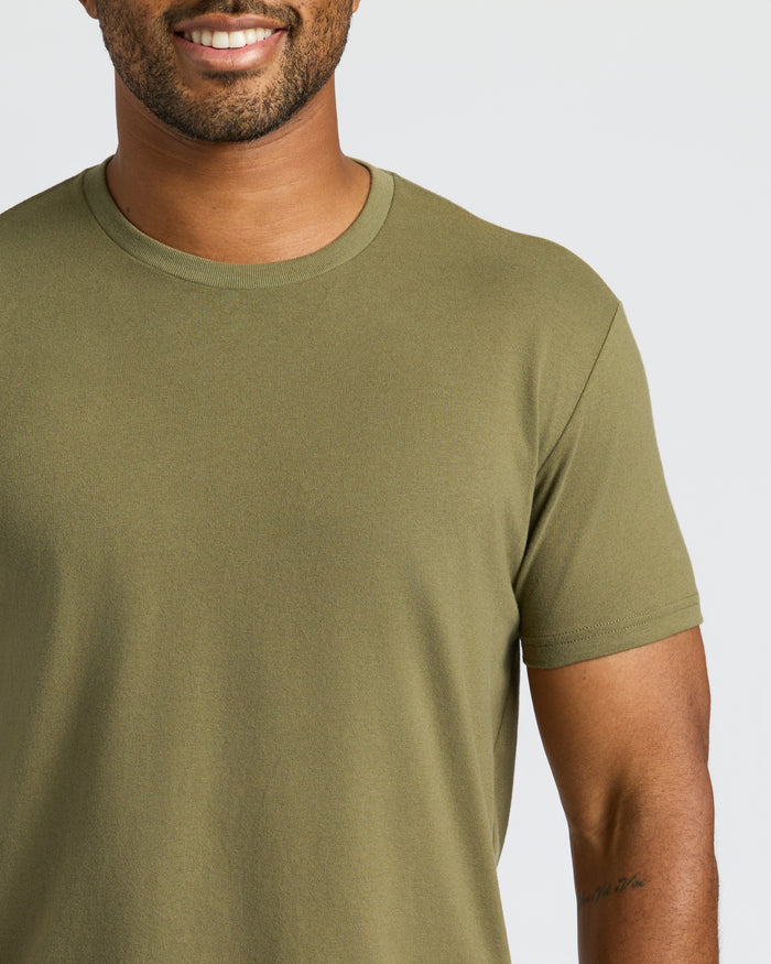 Man wearing Military Green Curved Hem Classic Crew Neck, showcasing its snug fit.