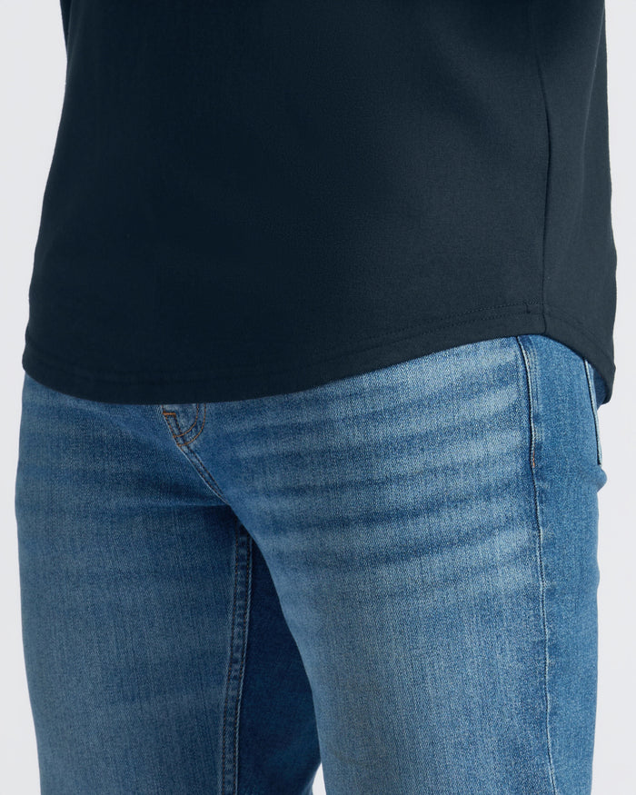 Close-up of blue jeans and a black shirt on a white background