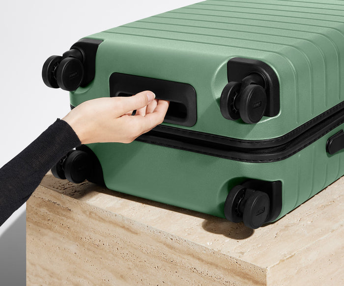 The Bigger Carry-On suitcase in Sea Green shown from below highlighting the underside grab handle
// 
Underside grab handle that makes it easier to lift and carry your suitcase.