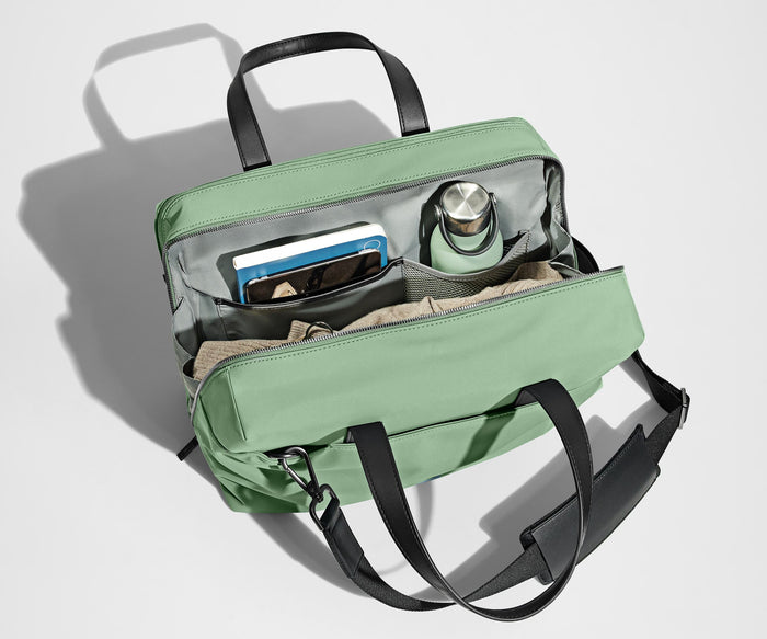 Main compartment packed with a light sweater, notebook, tablet, and water bottle. The detachable shoulder strap is clipped onto the bag.
// The Everywhere Bag features a detachable padded shoulder strap.