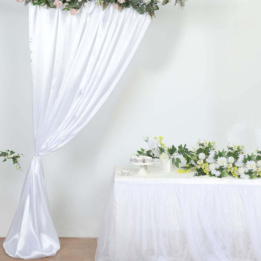 Elegant white drapery and floral arrangements for event decoration.